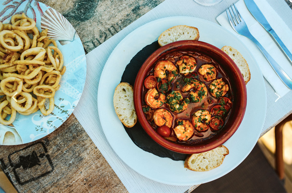 Enjoy a sun-kissed lunch on New Bounty Beach of Gambas Pil-Pil and some fried Calamares