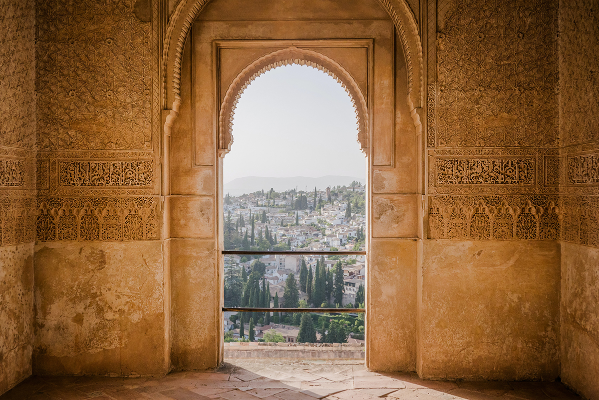 Granada city viewd through decorated arch of the Alahambra palace