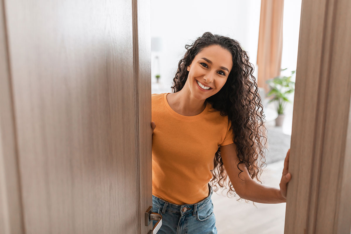 Woman opening the door with a smile