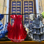 Feria dresses hanging to dry on an iron balcony or a rustic house.