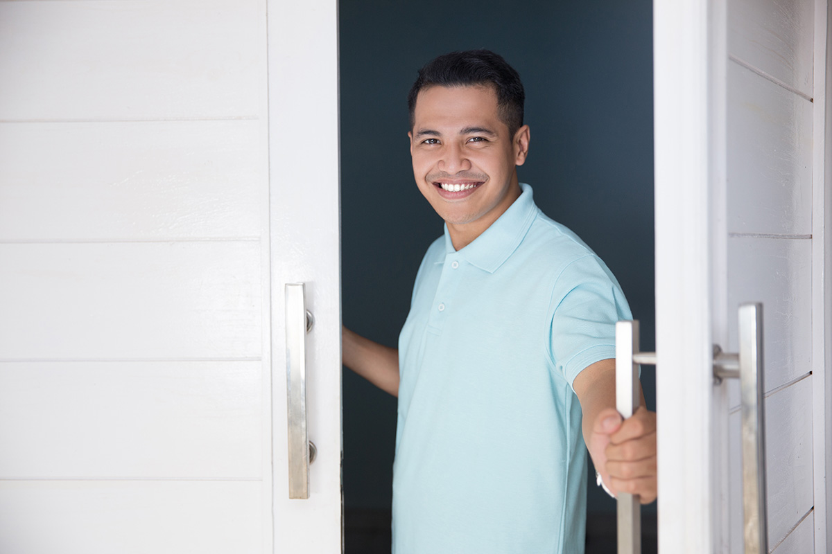 Man opening the door with a smile