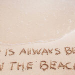 Life is always better on the beach written in the sand.