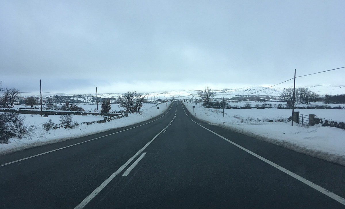 A clear road and a snowy landscape, on the “Ruta N-VI”.