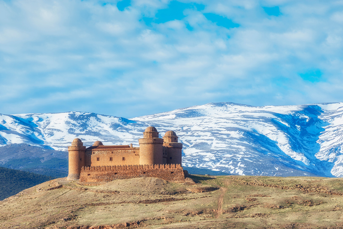 Castle of Calahorra in Granada province with snowey Sirerra Nevada in background.